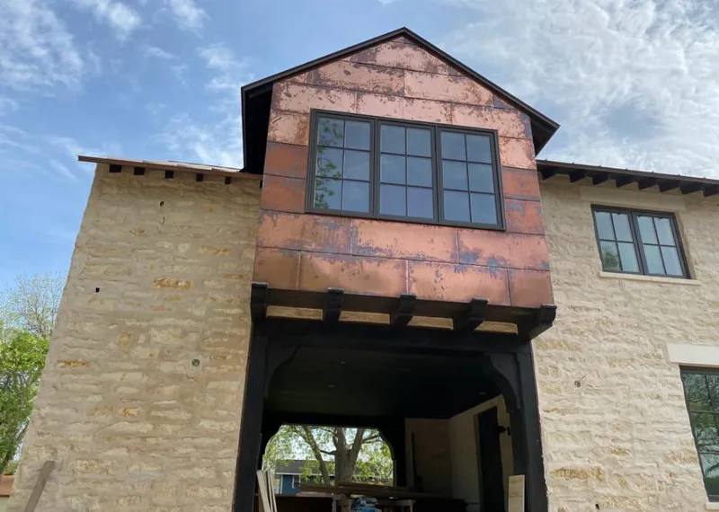 Copper metal panel facade on a stone building for Skylight Installation in Seabrook